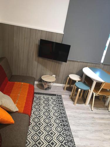 a living room with a couch and a table and a tv at Apartment Madeira Happiness in Funchal