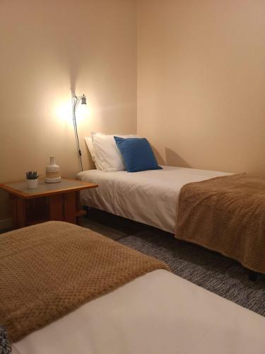 a bedroom with two beds and a table with a lamp at Apartment Madeira Happiness in Funchal