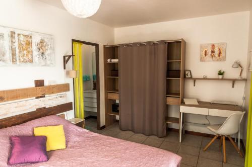 1 dormitorio con cama, escritorio y escritorio en Fleur de canne, en Sainte-Rose