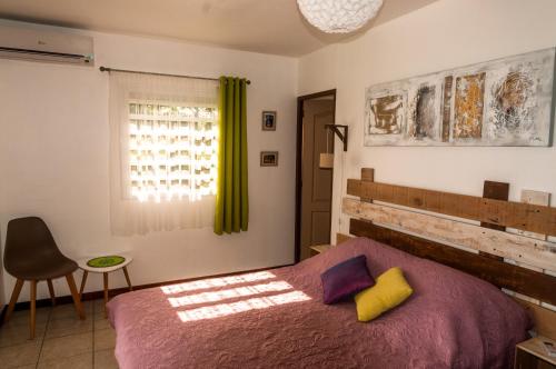 1 dormitorio con 1 cama, 1 silla y 1 ventana en Fleur de canne, en Sainte-Rose