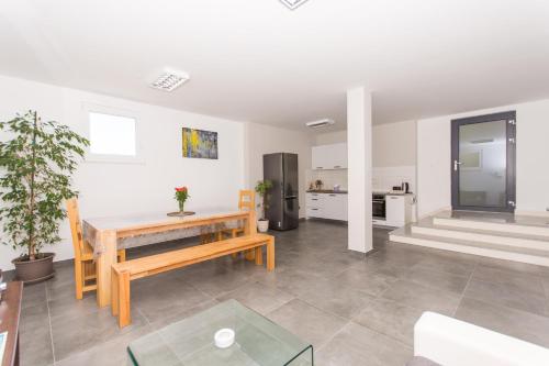 a living room with a wooden table and a kitchen at Villa Piramida in Trogir