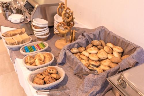 a table topped with bowls of bread and pastries at Stadthotel Donauwörth in Donauwörth