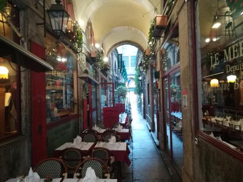 une ruelle avec des tables et des chaises dans un bâtiment dans l'établissement Studio Vieux Lyon, à Lyon