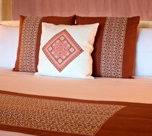 a bed with a pillow and two pillows at Cala de Mar Resort & Spa Ixtapa in Ixtapa
