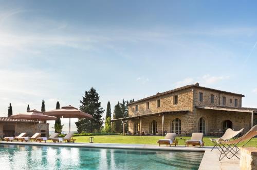 una casa con piscina frente a un edificio en Rosewood Castiglion del Bosco, en Castiglione del Bosco