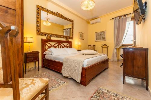 1 dormitorio con cama y espejo en B & B La Fontaine Residenza D'Epoca, en Viterbo
