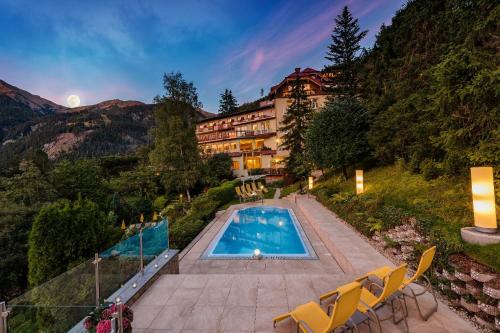 a hotel with a swimming pool in the mountains at Hotel Alpenblick in Bad Gastein