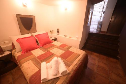 a bedroom with a large bed with red pillows at Casa Rural La Roca in Alcalá del Júcar