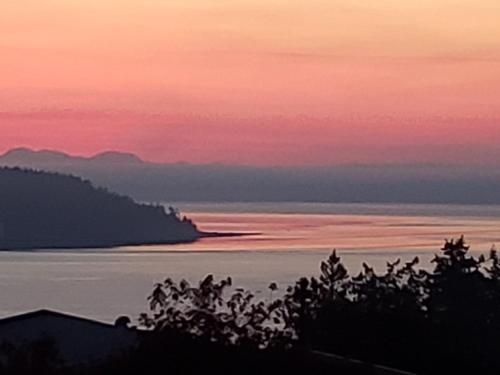 a view of the ocean at sunset at Above Tide Motel in Campbell River