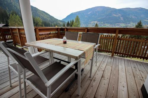 a wooden table and chairs on a deck with mountains at Appartement Panorama Loft in Bad Kleinkirchheim