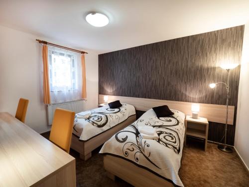 a hotel room with two beds and a table at Penzion Almada in Zvolen