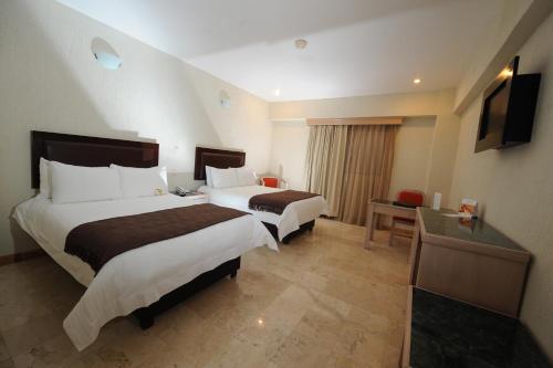 a hotel room with two beds and a television at Imperio de Angeles Executive León Poliforum in León