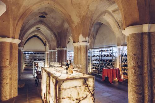 a wine cellar with a long table with wine glasses at Convento do Espinheiro, Historic Hotel & Spa in Évora