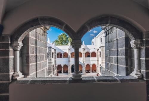 a view of a building through an archway at Convento do Espinheiro, Historic Hotel & Spa in Évora
