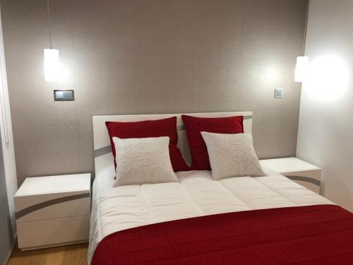- une chambre avec un lit doté d'oreillers rouges et blancs dans l'établissement Astro Vista Madeira Apartments, à Funchal