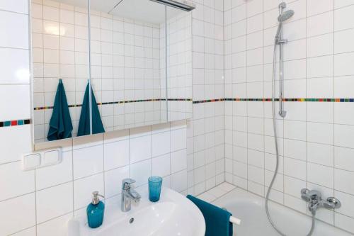 biała łazienka z umywalką i prysznicem w obiekcie Abendrot Appartement w mieście Ober-Hambach