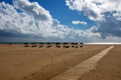 a group of umbrellas and chairs on a beach at Sol y Sombra Apartamento con entrada independiente in Isla del Moral