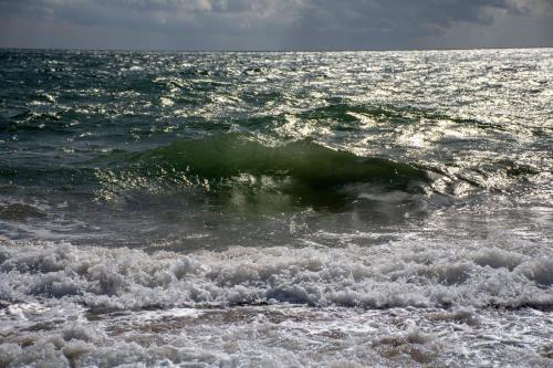 a small wave in the ocean on a beach at Sol y Sombra Apartamento con entrada independiente in Isla del Moral