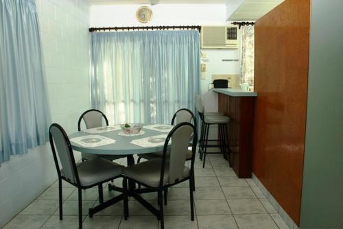 a dining room with a table and chairs and a kitchen at Sky View Units Bowen in Bowen
