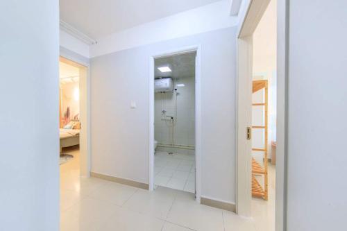 un pasillo con paredes blancas y una puerta abierta en Baoding Jingxiu·BaoDing Railway Station· Locals Apartment 00173430, en Baoding