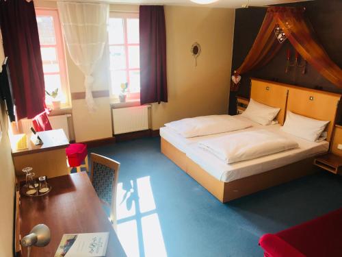 um quarto com uma cama, uma secretária e uma mesa em Altstadthotel Haßfurt GbR em Hassfurt