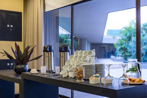 a buffet with plates and glasses on a table at Movich Hotel de Pereira in Pereira