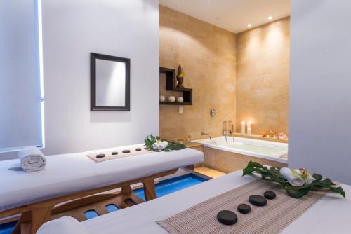 a bathroom with a tub and a sink and a bath tub at Movich Hotel de Pereira in Pereira