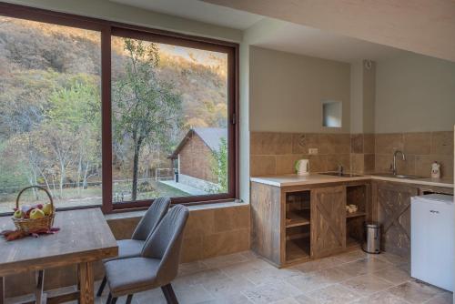 a kitchen with a table and a large window at Apricot Aghveran Resort in Agveran