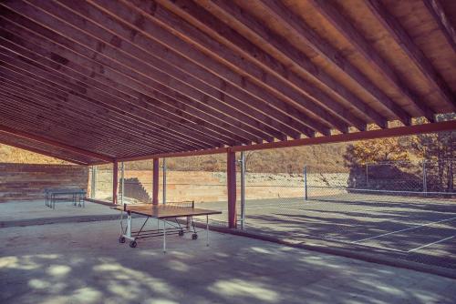 a pavilion with a table and a tennis court at Apricot Aghveran Resort in Agveran