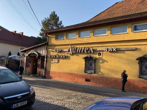 un bâtiment jaune sur le côté d'une rue dans l'établissement Hotel Daniel, à Moukatcheve