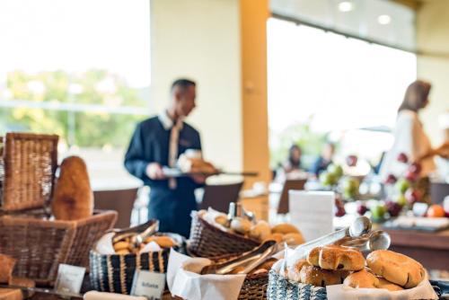 a man standing behind a table with baskets of bread at Movich Hotel de Pereira in Pereira