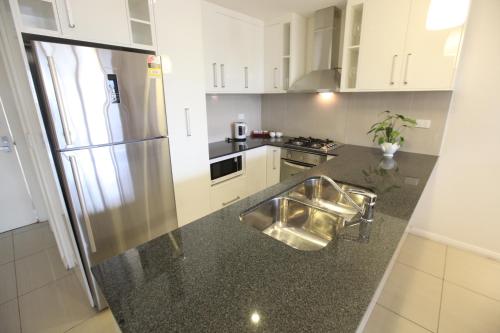 a kitchen with a stainless steel refrigerator and a counter at Premiere Apartments in Nadi