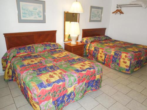 a hotel room with two beds and a lamp at Skylark Resort Motel in Wildwood