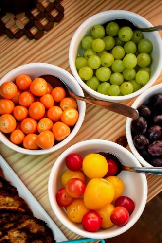 four bowls of different types of fruit on a table at Cooper Hotel Boutique in Cusco