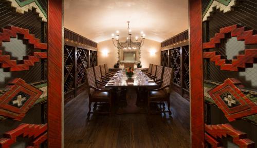 a dining room with a long table and a chandelier at Rosewood Inn of the Anasazi in Santa Fe