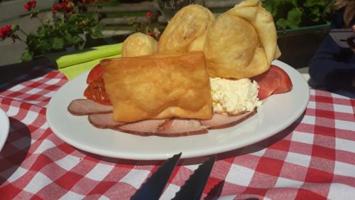 a plate of food with meat and bread on a table at Select Lux Angella-Konaci in Kopaonik