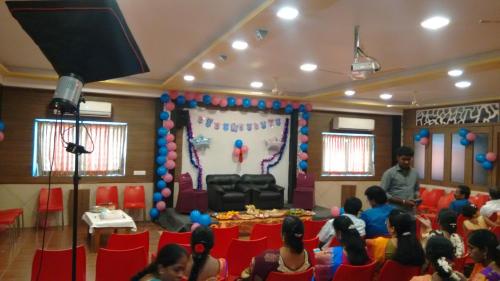 a group of people sitting in chairs in a room at Kohinoor Hotels in Erode