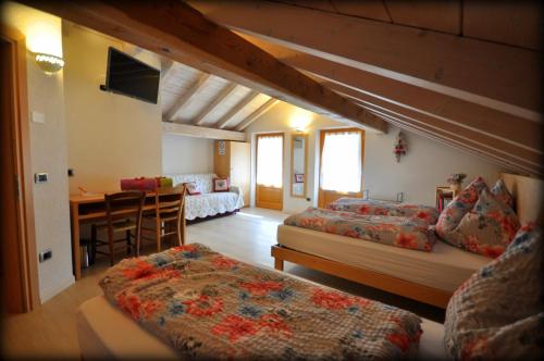 a living room with two beds and a dining room at Camere Nordest Sudest- Conca Agordina in Agordo