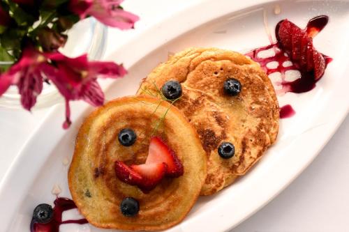 a white plate with pancakes with strawberries and blueberries at Cooper Hotel Boutique in Cusco