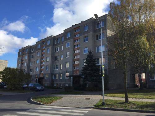 a tall building with a street light in front of it at Apartamentai Dainų in Šiauliai