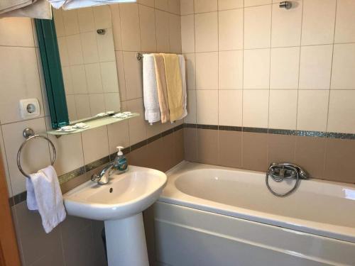 ein Badezimmer mit einem Waschbecken, einer Badewanne und einem Waschbecken in der Unterkunft Hotel Four Seasons in Samokow