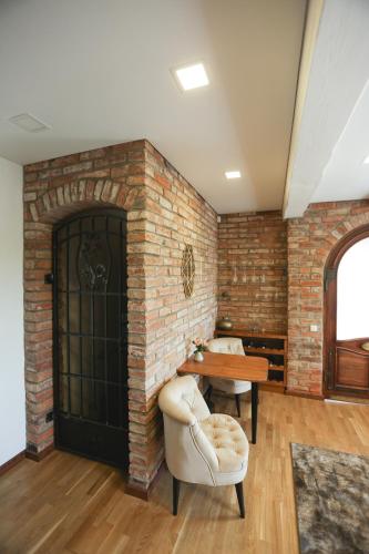 a room with a brick wall and a table and chairs at Lavender Inn Guest House in Viešvėnai