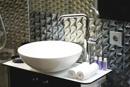 a white bowl sink on a counter in a bathroom at Lavender Inn Guest House in Viešvėnai