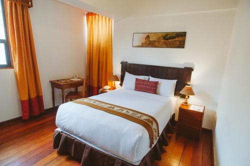 a bedroom with a large white bed in a room at Hotel Monasterio San Pedro in Cusco