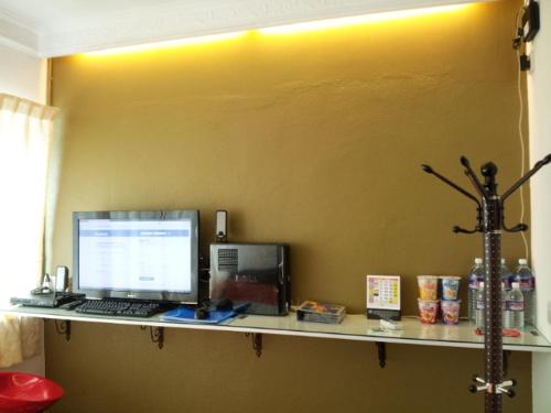 a desk with a computer on top of a wall at Fastbook Bendera Home 8 & 10pax in Ayer Itam