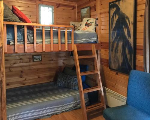 ein Etagenbett und ein Stuhl in einer Hütte in der Unterkunft Fivespot Cabin in Pinehurst