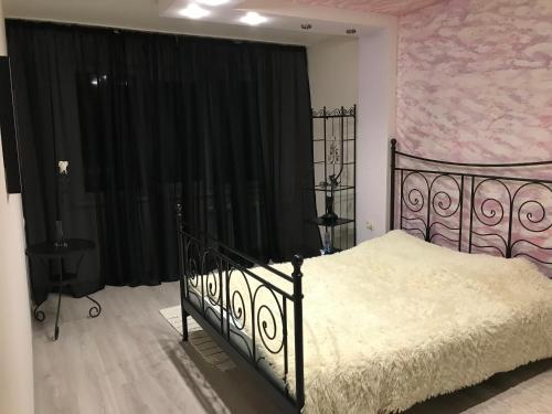 キロフスクにある50 лет октября дом 33のピンクの壁のベッドルーム1室(黒いベッド1台付)