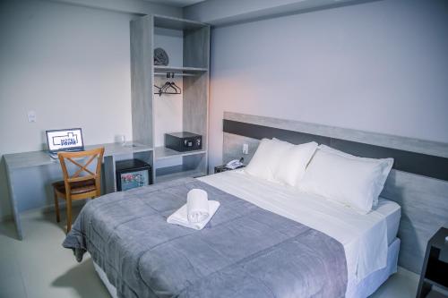 Un dormitorio con una cama con una servilleta blanca. en Hotel Prime Executive, en Campos Novos