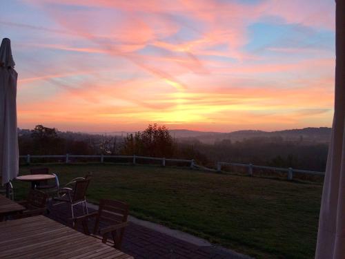 a view of a sunset from the porch of a house at Hotel La Venerie in Virton