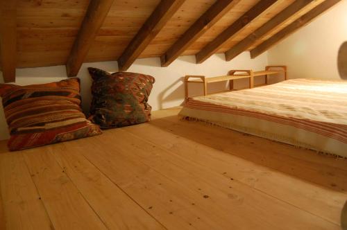 a bedroom with a bed and pillows on a wooden floor at Chalet à Bazian in Bazian
